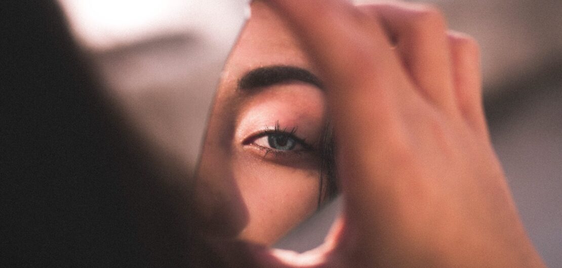 reflection of woman s eye on broken mirror