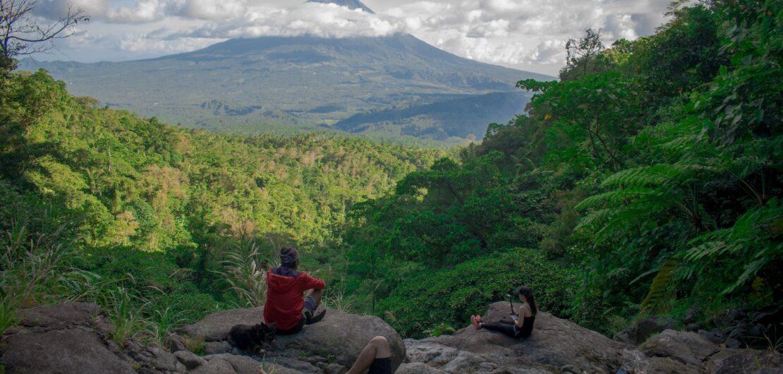 photo of group of people sitting on rock formation