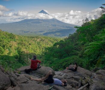 photo of group of people sitting on rock formation