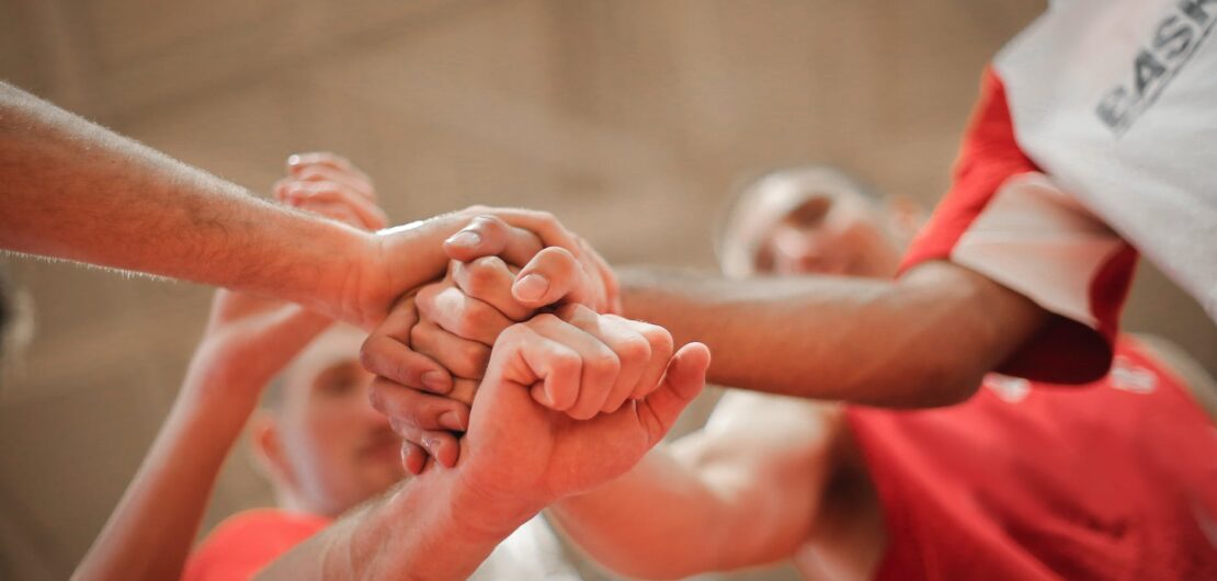 basketball team stacking hands together